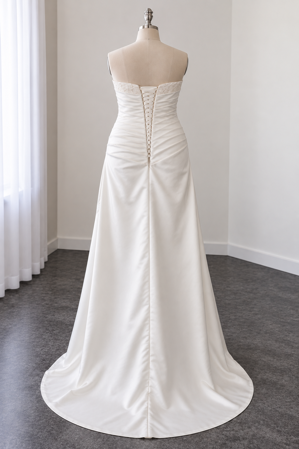 Schlichtes Curvy Brautkleid in Mikadostoff von Hinten zu sehen. Trägerlos, Oberteil in Falten gelegt und mit Spitzenapplikationen